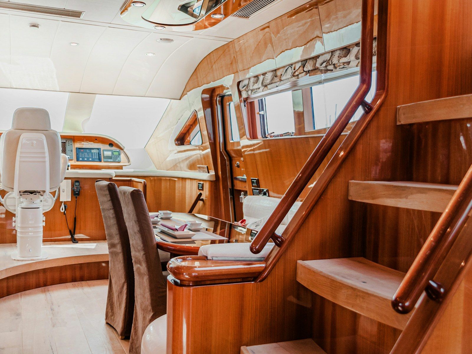 Intérieur de bateau en bois verni : carré, table et escalier de descente